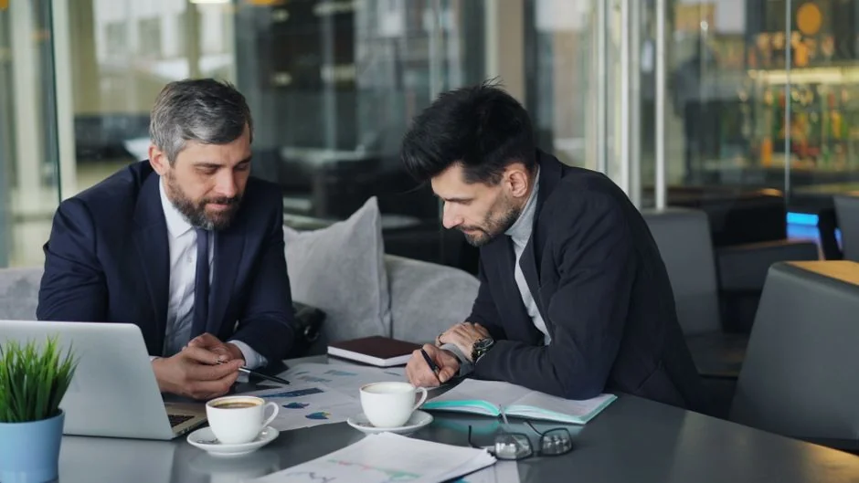 Une équipe variée travaille ensemble sur des stratégies de marketing digital autour d’un bureau, avec des ordinateurs portables et des tablettes.